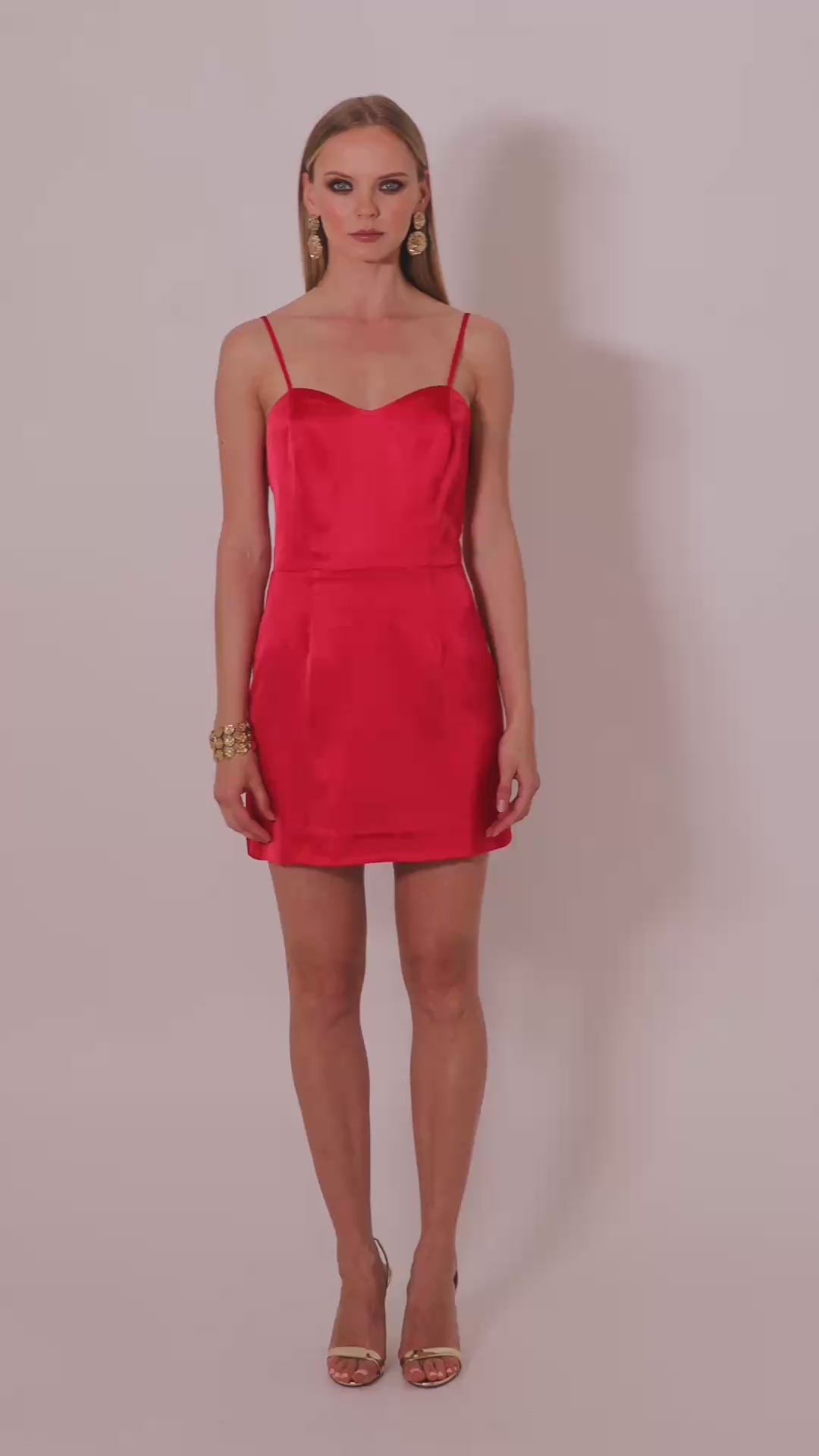 Model wearing the Gohar red satin mini dress by Leochèle turns and walks out of frame