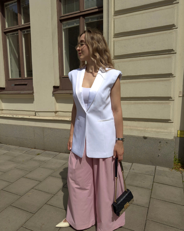 Woman wearing the Roza sleeveless blazer in white by Leochèle outdoors in sunlight